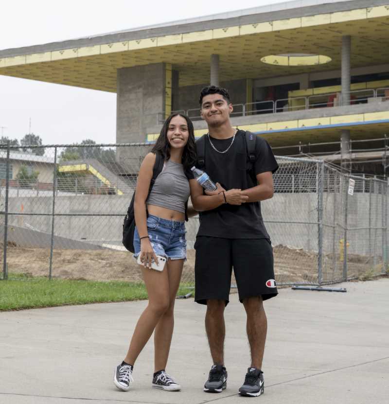 学生们在学生中心建筑工地前摆姿势