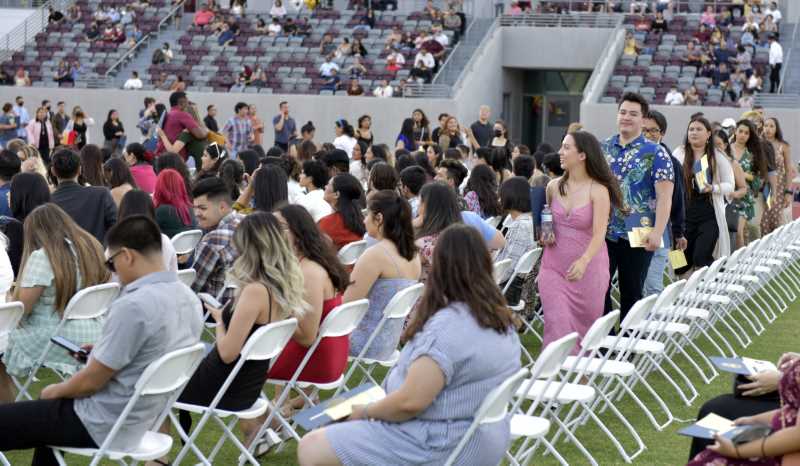 Grads sitting on field